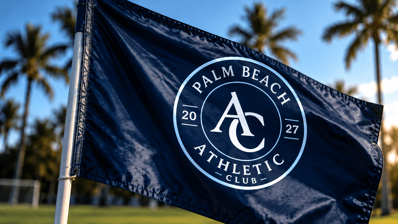 Palm Beach Athletic corner flag with the club crest, palm trees at sunset in the background